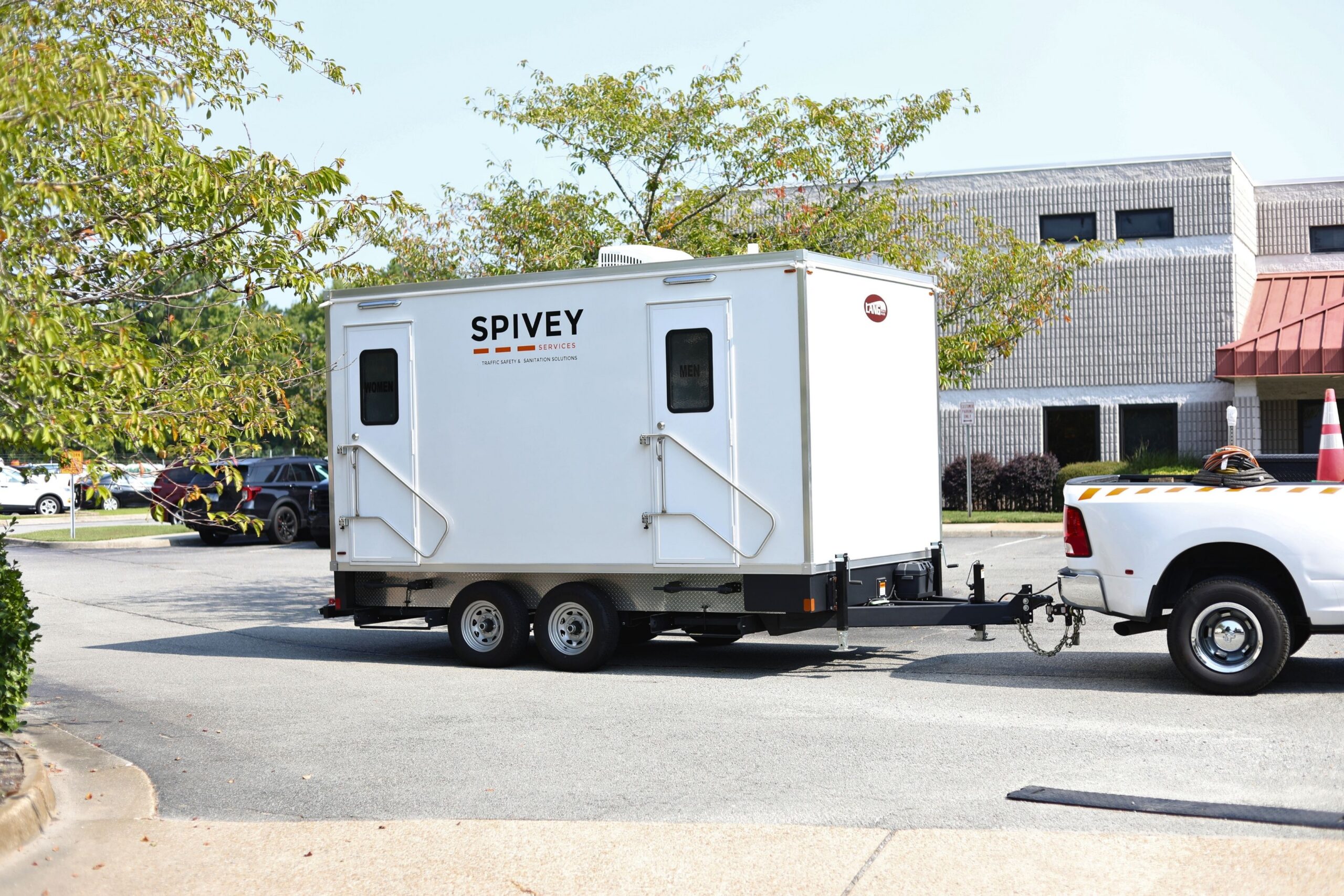Spivey Services restroom trailer rental being towed by a truck